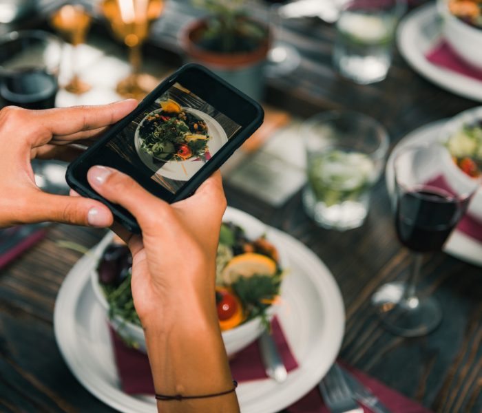 Women Photographing Salad With Smart Phone in Vegetarian Restaurant.